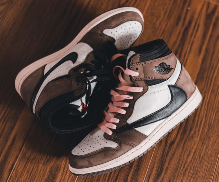 a-pair-of-brown-and-white-sneakers-on-a-wooden-floor