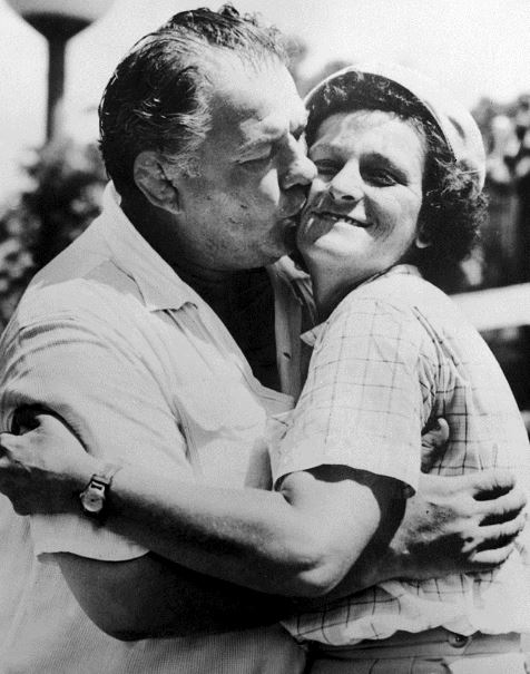 black and white photo of Babe Didrikson Zaharias and her husband kissing her cheeks
