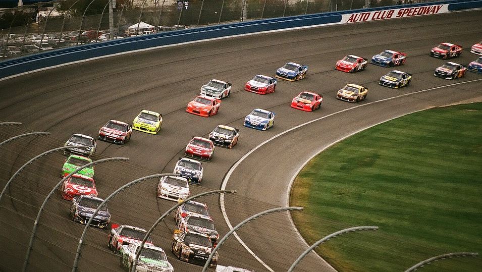 cars racing back-to-back on a curve track, in a chainlike fashion