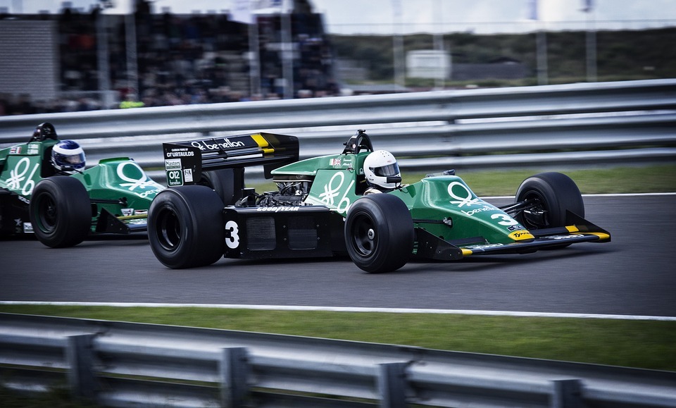 two green F1 cars racing on a track