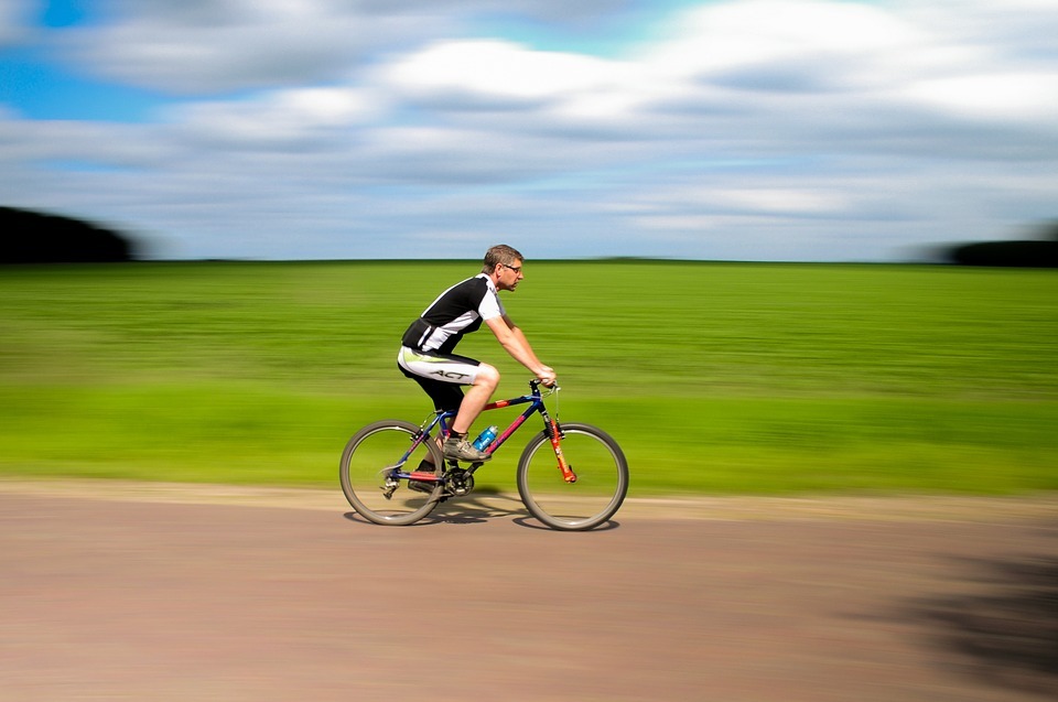 a man cycling fast on a road