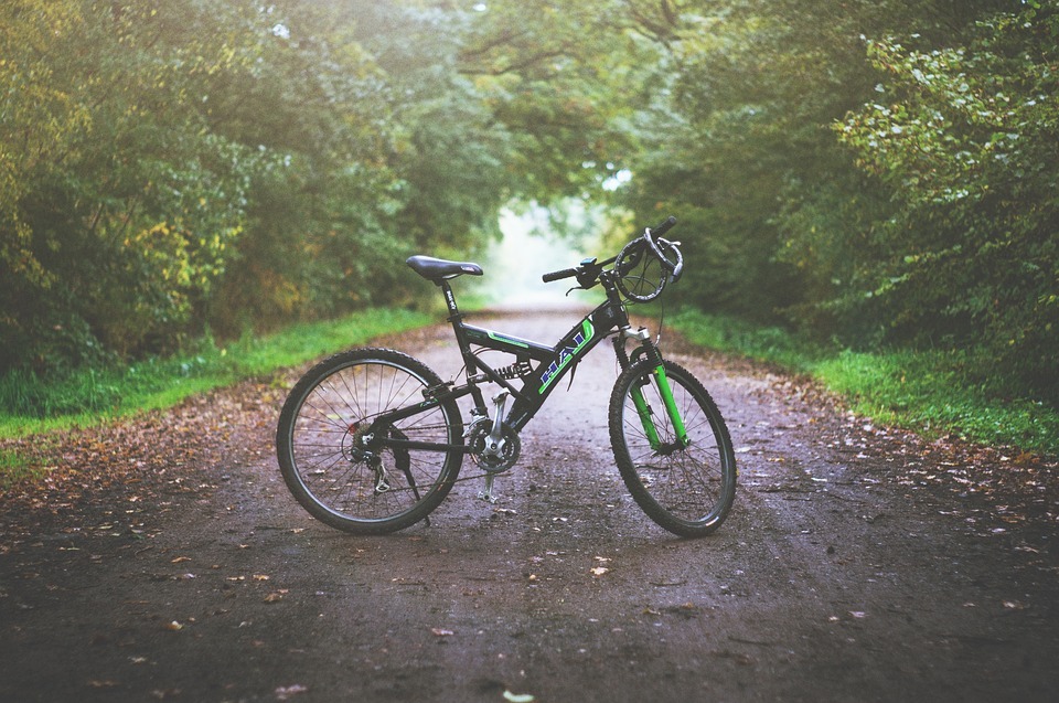 a mountain bike with green color parked in the middle of the road