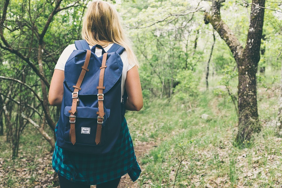 a woman with a backpack, in a forest