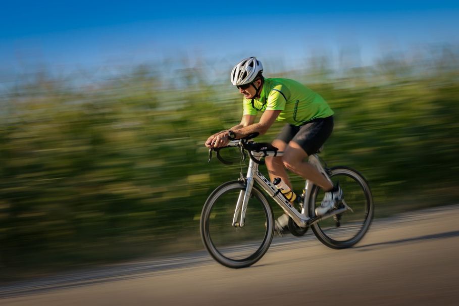 a cyclist in green jersey riding a bike in a blurred background