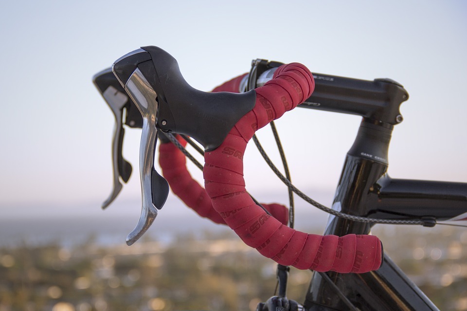bicycle handlebar wrapped in light red rubber coating