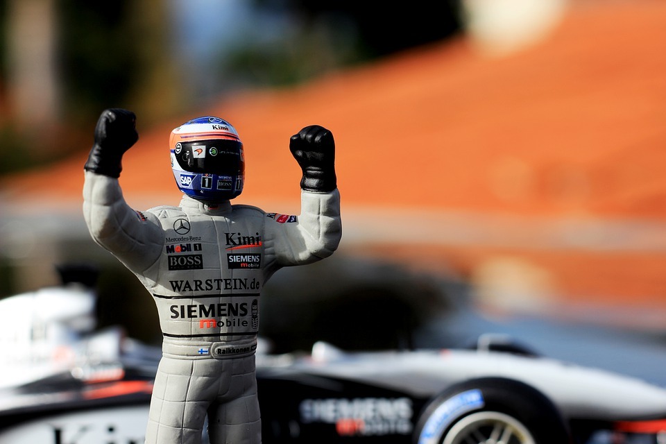 an F1 driver wearing a gray suit and a helmet