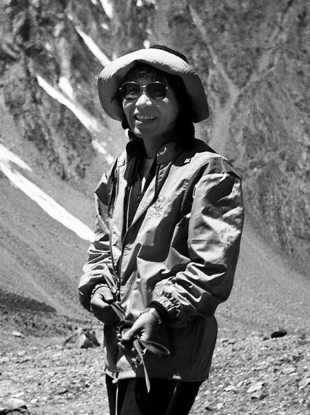 black and white photo of Junko Tabei smiling while climbing a mountain