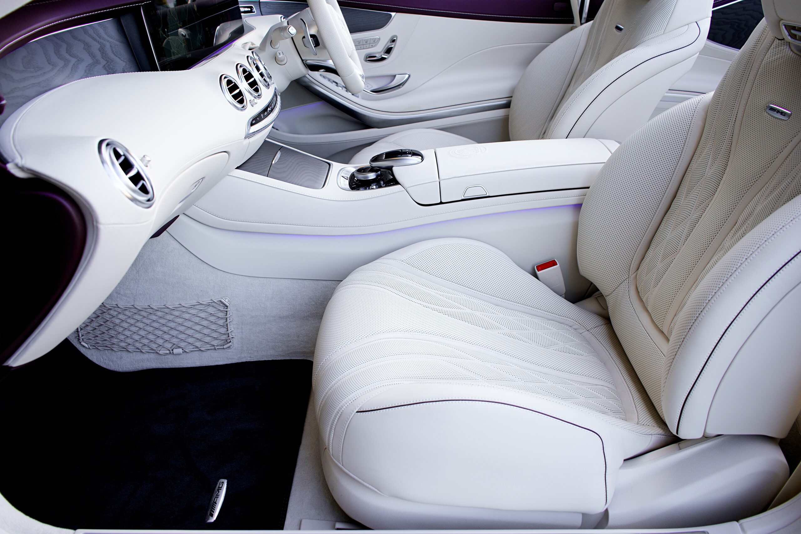 A car interior with white leather seats