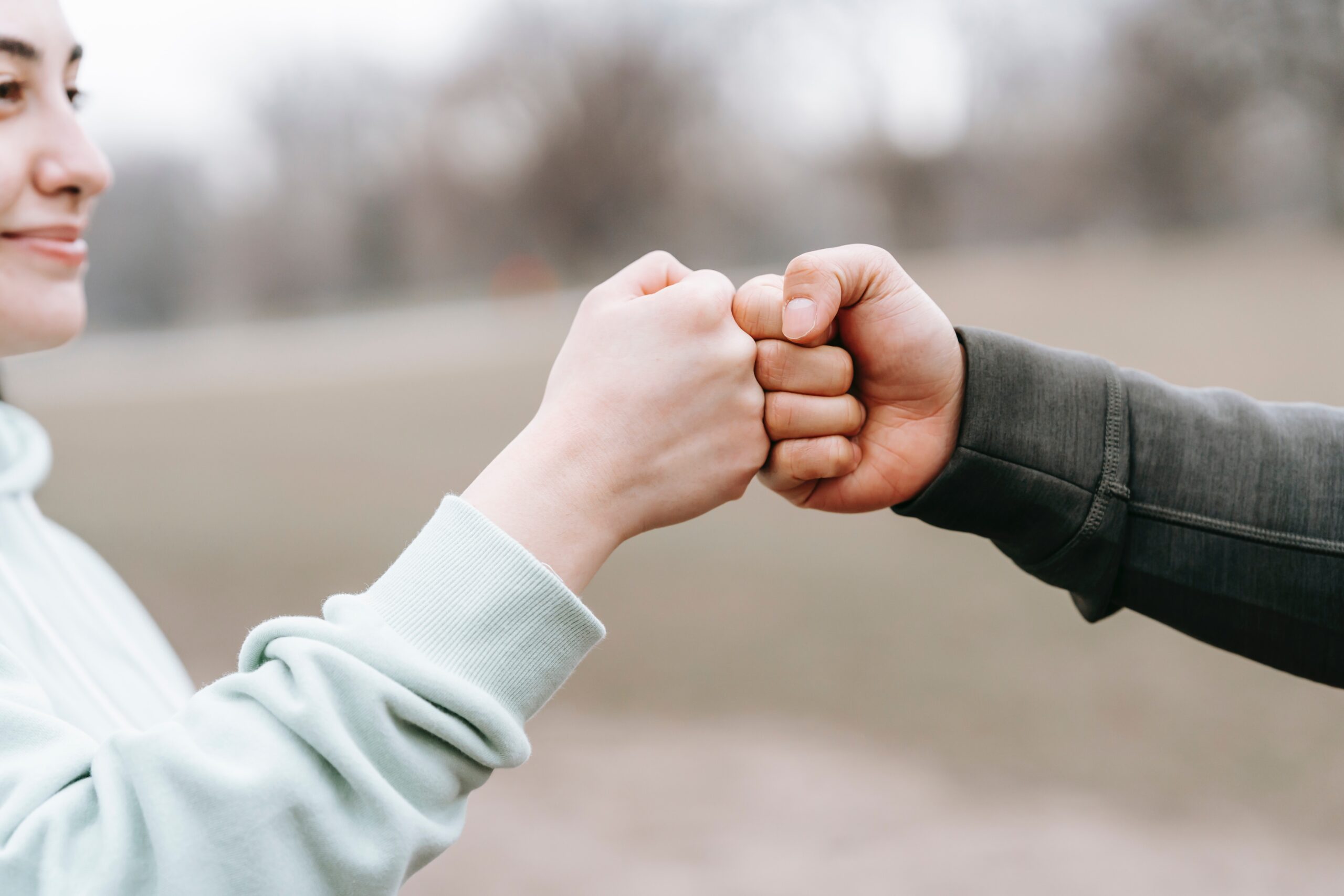 man and happy woman greeting each other with a fist bump